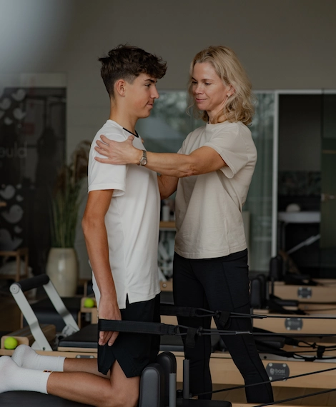 Pilates treener juhendab noort osalejat Bluebird stuudios Laagris – treening keskendub rühi, tasakaalu ja kehatunnetuse arendamisele.