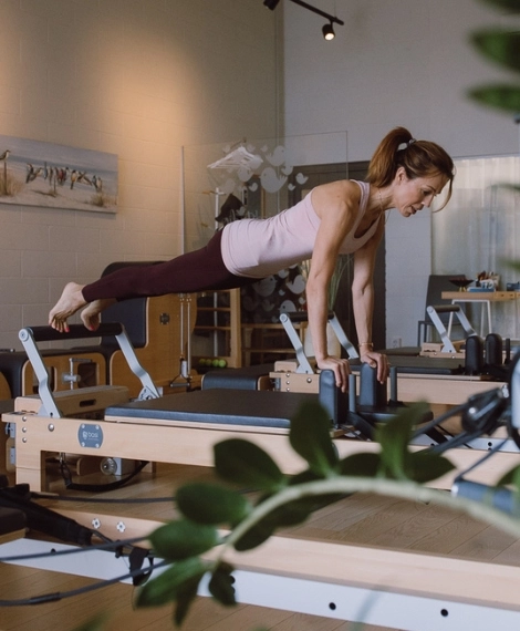 Pilates Reformer treening Bluebird stuudios Laagris – juhendaja sooritab harjutust stuudio saalis, keskendudes jõule ja kehakontrollile.