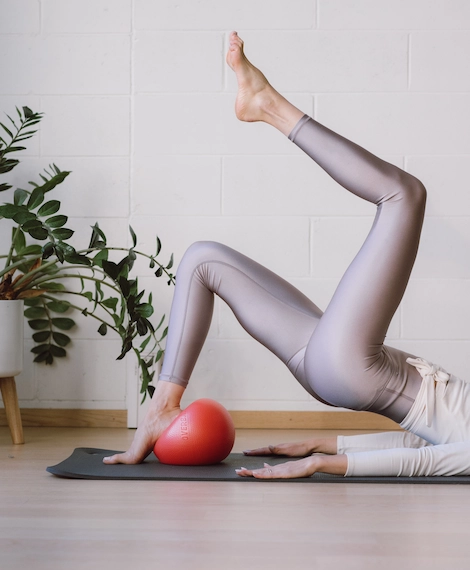 Pilates harjutus matil Bluebird stuudios Laagris – treening väikese palliga, keskendudes jalgade ja kerelihaste tugevdamisele.